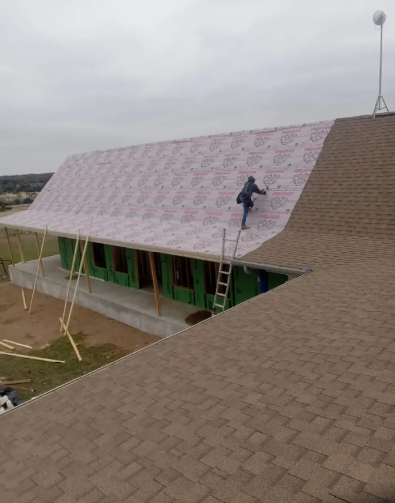 Worker preparing underlayment for a metal roof installation in Bolingbrook